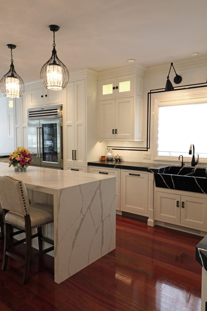 Large transitional u-shaped dark wood floor and red floor eat-in kitchen photo in Boston with a farmhouse sink, beaded inset cabinets, white cabinets, quartz countertops, white backsplash, porcelain backsplash, stainless steel appliances and an island