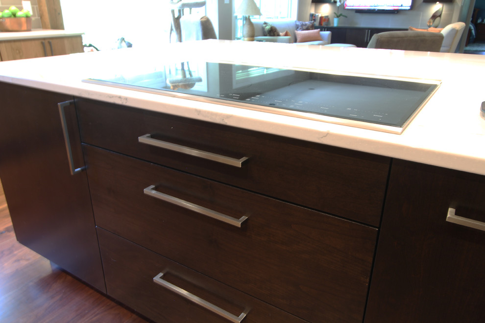 Example of a large transitional l-shaped medium tone wood floor and brown floor open concept kitchen design with an undermount sink, flat-panel cabinets, medium tone wood cabinets, quartz countertops, gray backsplash, porcelain backsplash, stainless steel appliances and an island