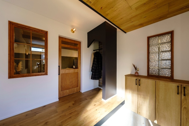 Cette photo montre une entrée avec un mur blanc, une porte simple, une porte grise, un sol beige, un plafond en bois et du papier peint.