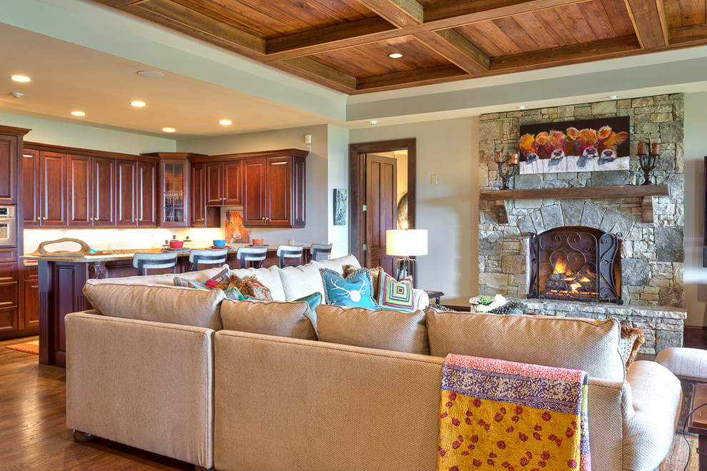 This is an example of a mid-sized country open concept family room in Charlotte with beige walls, medium hardwood floors, a standard fireplace and a stone fireplace surround.
