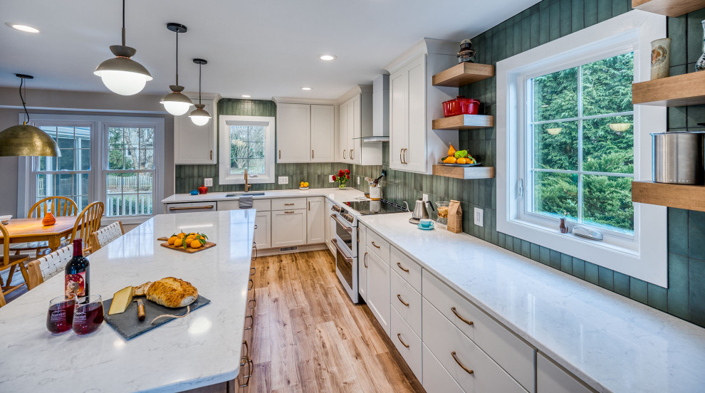 This is an example of a large traditional kitchen in DC Metro with flat-panel cabinets, white cabinets, engineered stone countertops, green splashback, ceramic splashback, an island and white worktops.