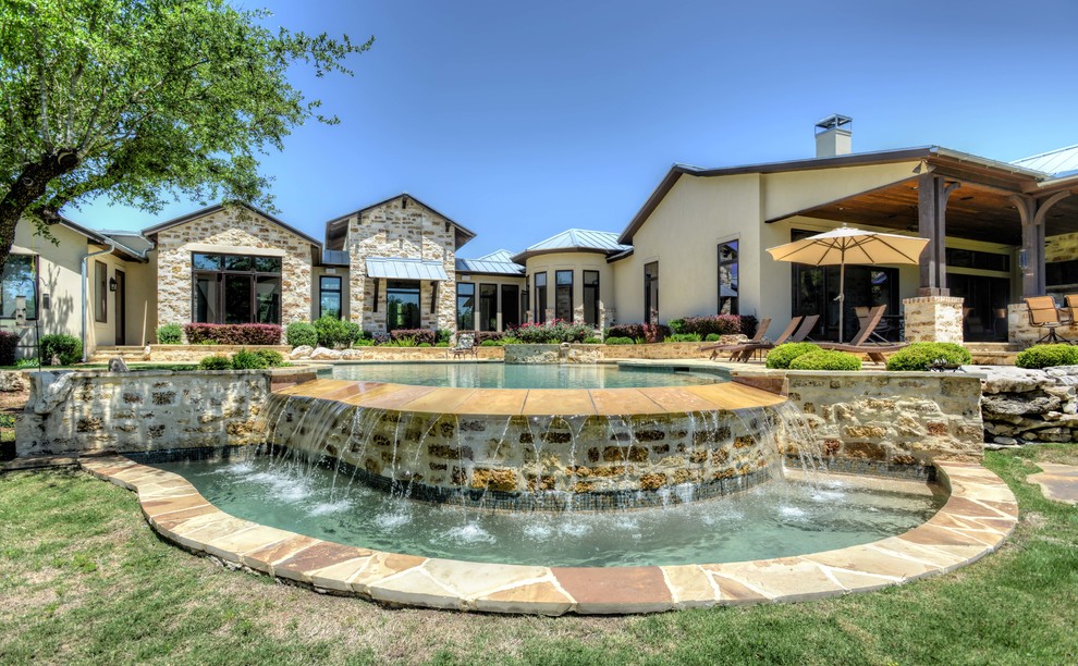 Pool - large rustic backyard stone and custom-shaped infinity pool idea in Austin
