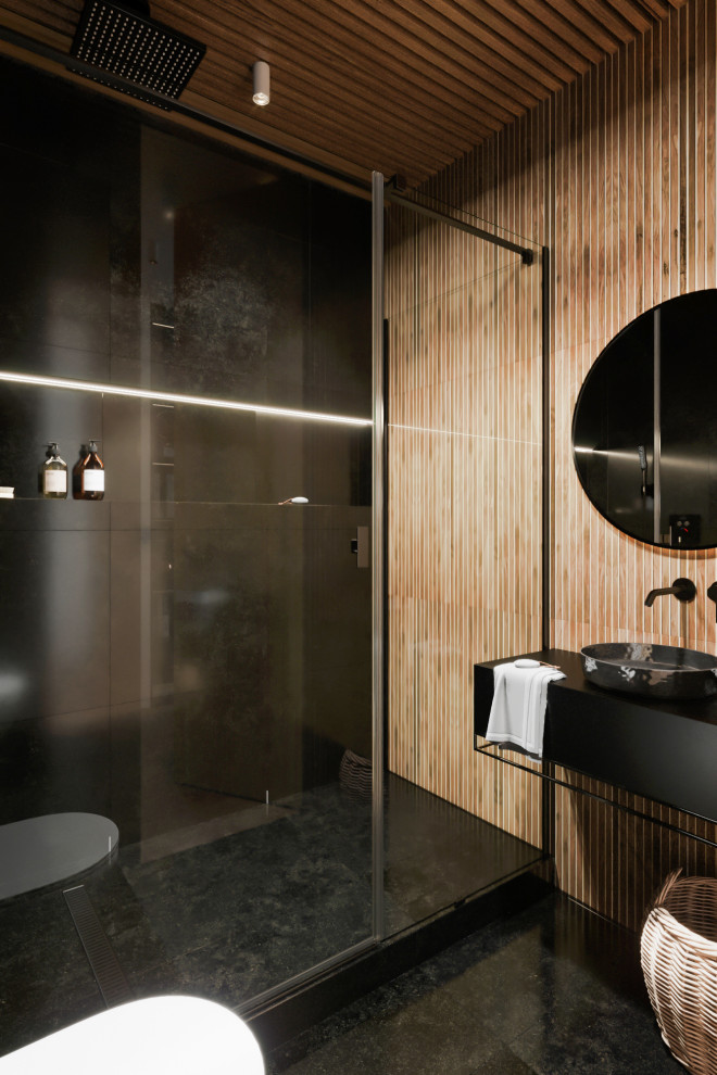 This is an example of a mid-sized contemporary 3/4 bathroom in Other with flat-panel cabinets, black cabinets, a wall-mount toilet, beige tile, porcelain tile, black walls, porcelain floors, solid surface benchtops, black floor, black benchtops, an alcove shower, a vessel sink, a hinged shower door and wood.