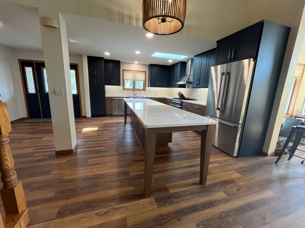 Large transitional l-shaped eat-in kitchen photo with shaker cabinets, quartz countertops and an island
