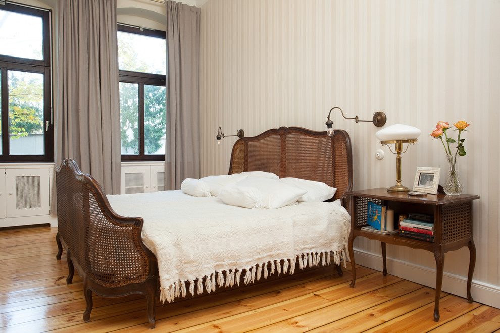 Design ideas for a mid-sized traditional bedroom in Berlin with beige walls, light hardwood floors, no fireplace and yellow floor.