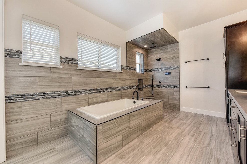 This is an example of a large modern master bathroom in Sacramento with a drop-in tub, a shower/bathtub combo, a one-piece toilet, multi-coloured tile, ceramic tile, white walls, porcelain floors, a drop-in sink, engineered quartz benchtops, grey floor, an open shower, grey benchtops, an enclosed toilet, a double vanity and a built-in vanity.