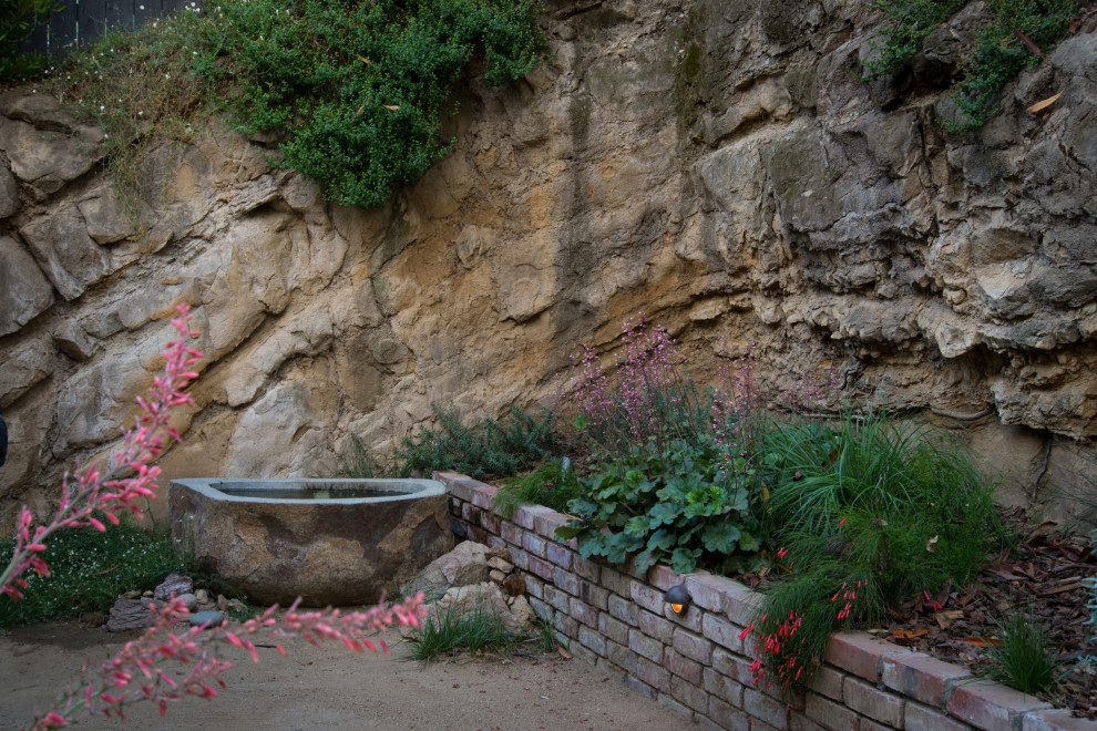 Inspiration for a small modern backyard partial sun xeriscape for spring in Los Angeles with a water feature.