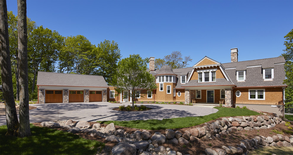 This is an example of a large beach style two-storey brown house exterior in Minneapolis with mixed siding, a shingle roof and a gambrel roof.