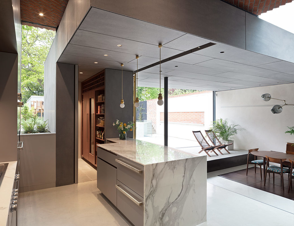 Design ideas for a large contemporary l-shaped open plan kitchen in London with an undermount sink, flat-panel cabinets, grey cabinets, marble benchtops, white splashback, marble splashback, stainless steel appliances, concrete floors, with island, grey floor and white benchtop.