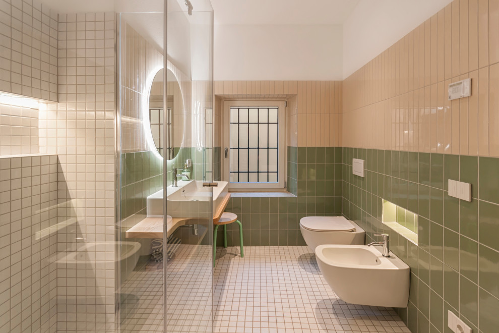 Inspiration för små moderna toaletter, med släta luckor, skåp i ljust trä, en vägghängd toalettstol, keramikplattor, gröna väggar, mosaikgolv, ett fristående handfat, träbänkskiva och vitt golv