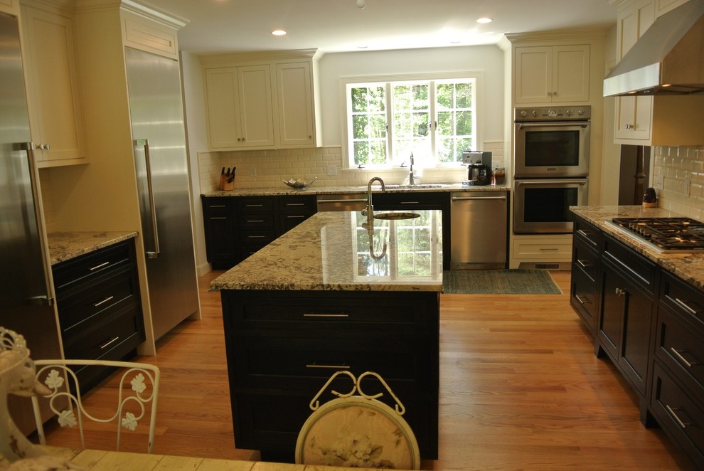 Example of a transitional light wood floor eat-in kitchen design in Boston with an undermount sink, shaker cabinets, granite countertops, white backsplash, subway tile backsplash, stainless steel appliances and an island
