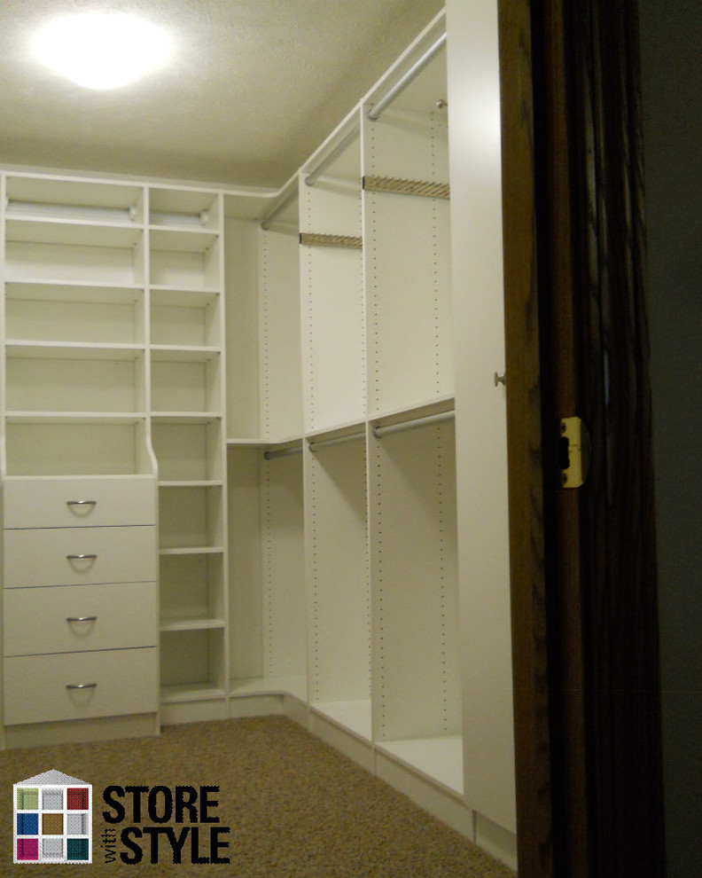 Expansive modern gender-neutral walk-in wardrobe in Cleveland with flat-panel cabinets, white cabinets and carpet.