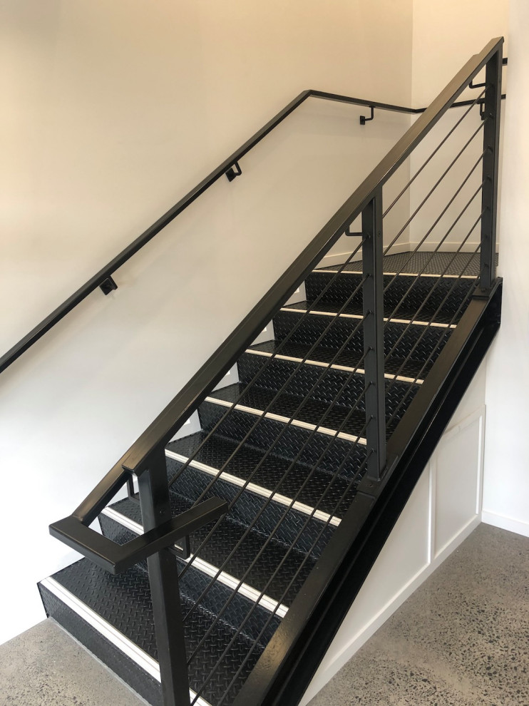 Design ideas for a large industrial metal l-shaped staircase in Auckland with metal risers and metal railing.
