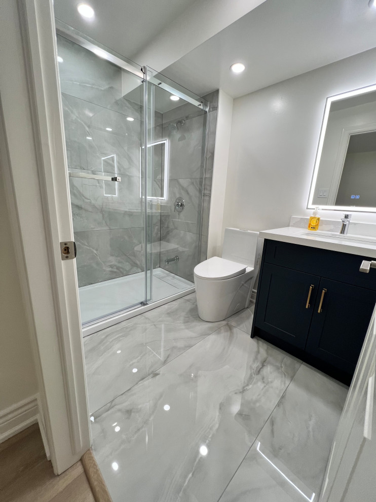This is an example of a mid-sized asian 3/4 bathroom in Toronto with shaker cabinets, white cabinets, an alcove tub, a shower/bathtub combo, a one-piece toilet, white tile, porcelain tile, porcelain floors, an undermount sink, quartzite benchtops, white floor, a sliding shower screen, white benchtops, a niche, a single vanity and a freestanding vanity.