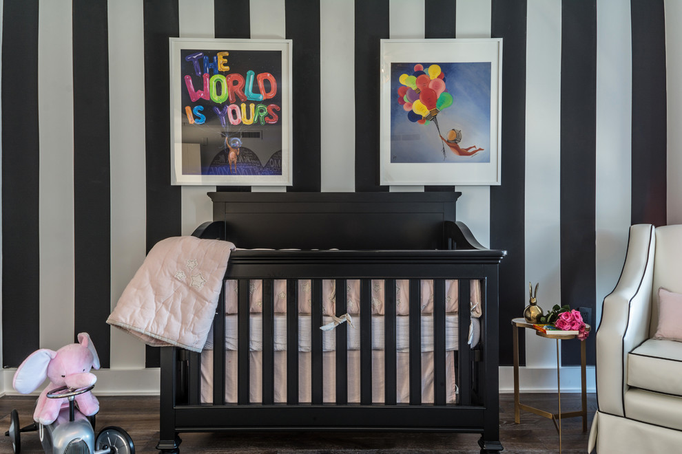 Photo of a mid-sized contemporary nursery for girls in New York with multi-coloured walls, dark hardwood floors and brown floor.