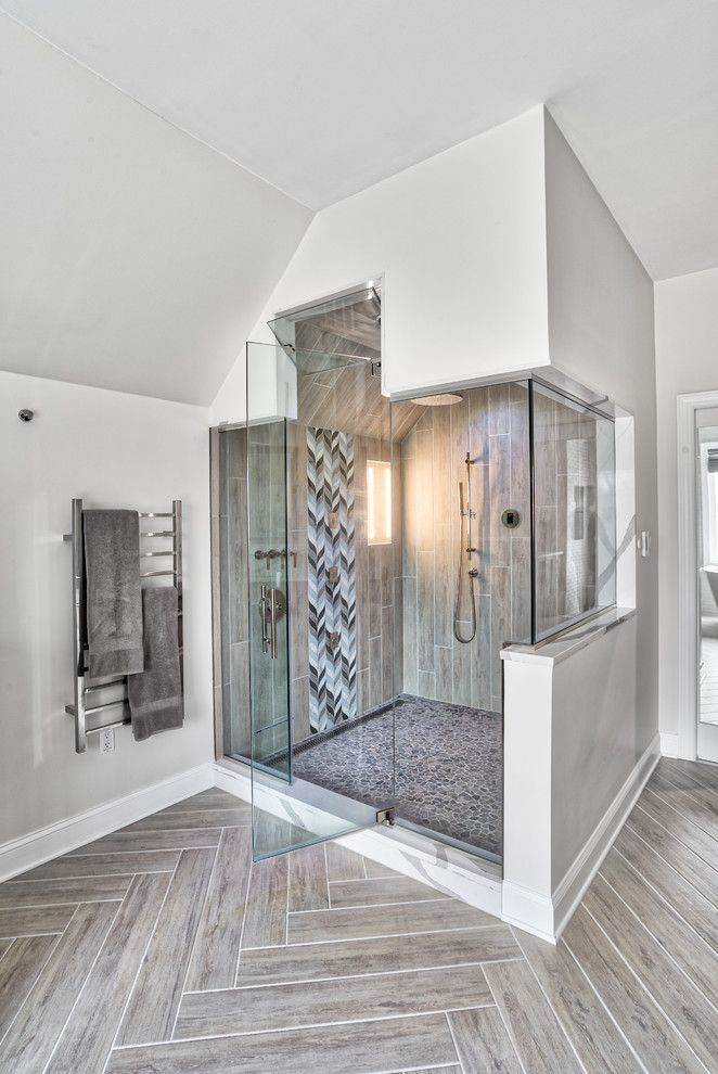 Photo of an expansive transitional master bathroom in New York with shaker cabinets, dark wood cabinets, a freestanding tub, an alcove shower, gray tile, glass tile, beige walls, an undermount sink, engineered quartz benchtops, a hinged shower door and white benchtops.