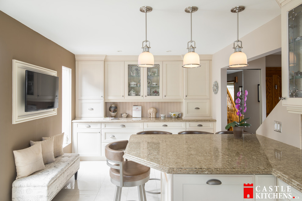 Enclosed kitchen - mid-sized transitional galley porcelain tile enclosed kitchen idea in Toronto with an undermount sink, shaker cabinets, beige cabinets, quartzite countertops, beige backsplash, stainless steel appliances and an island