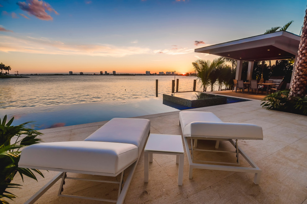This is an example of an expansive world-inspired back ground level terrace in Tampa with a dock and a pergola.