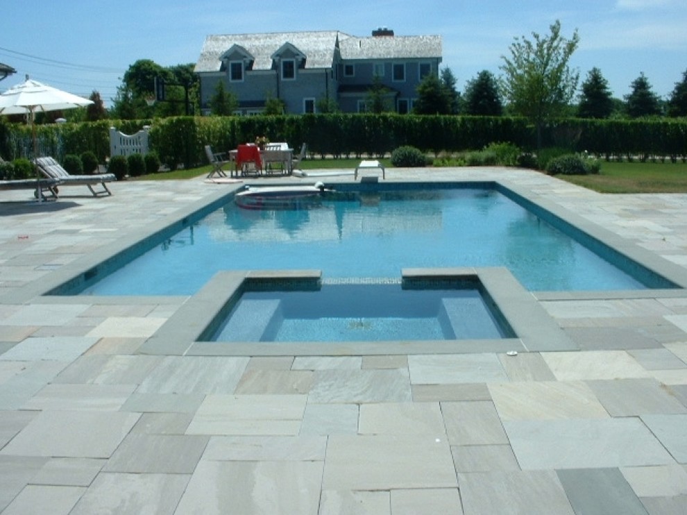 Traditional backyard custom-shaped natural pool in New York with a hot tub and natural stone pavers.