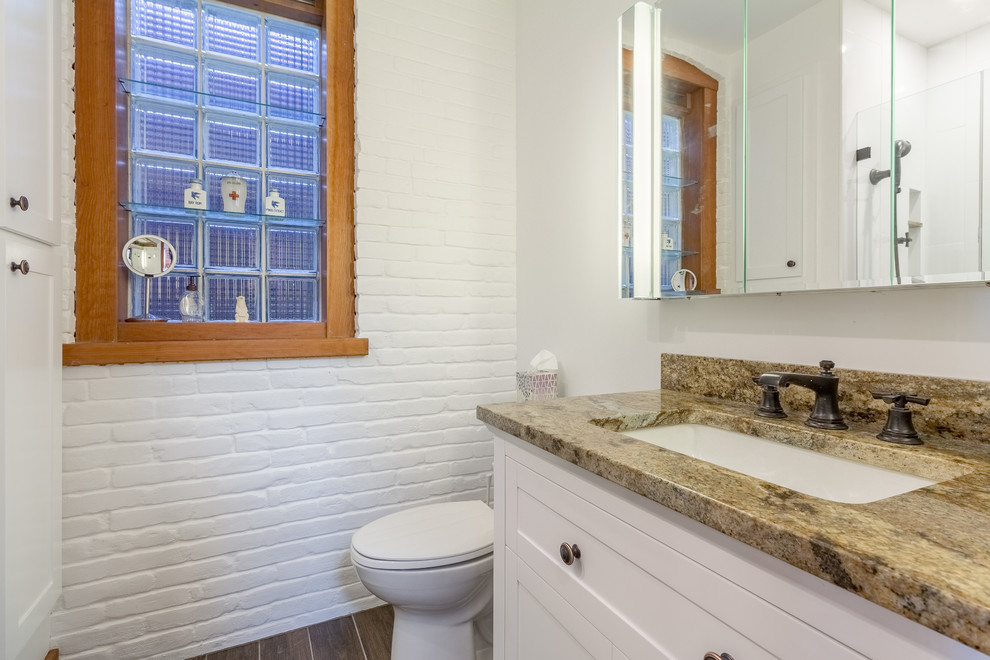 Small transitional 3/4 bathroom in Boston with shaker cabinets, white cabinets, white walls, granite benchtops, a one-piece toilet, white tile, an undermount sink, brown floor and brown benchtops.
