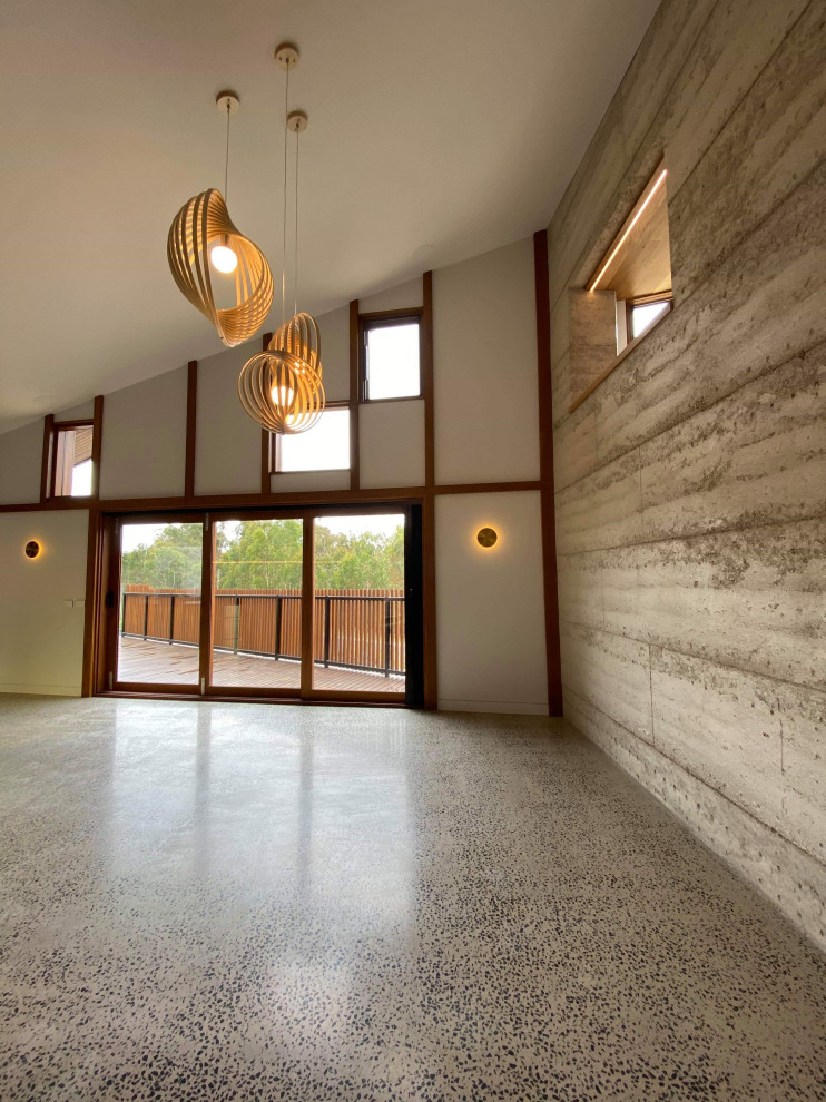 На фото: большая гостиная-столовая в стиле лофт с серыми стенами, бетонным полом и серым полом с