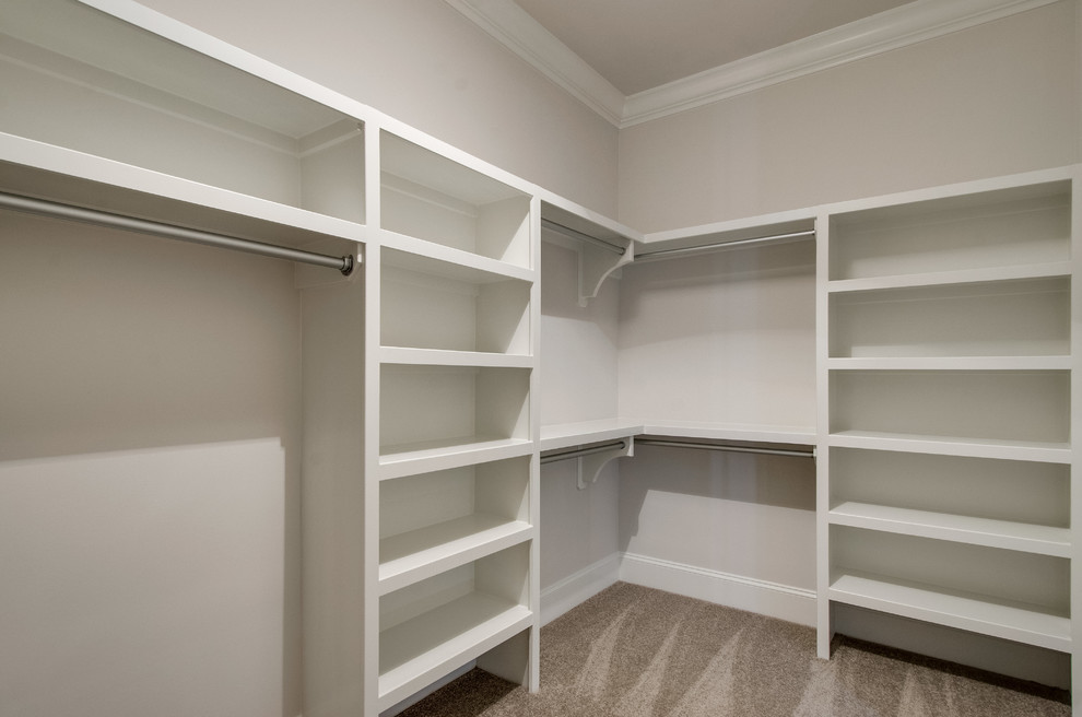 Expansive traditional gender-neutral walk-in wardrobe in Nashville with open cabinets, white cabinets and carpet.