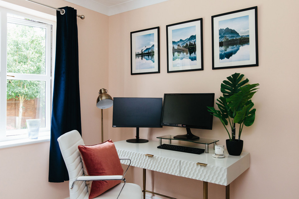 Modelo de despacho minimalista de tamaño medio con paredes rosas y escritorio independiente