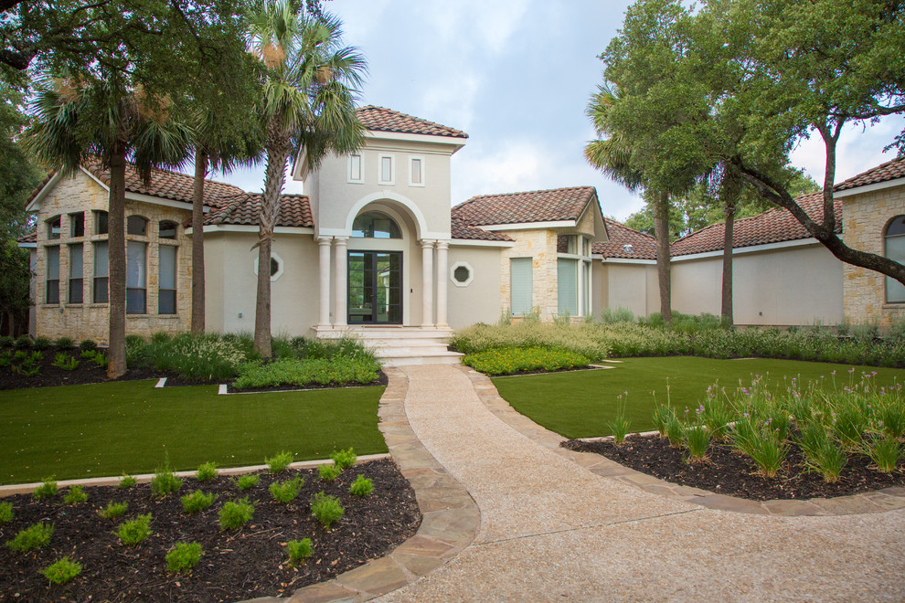 Large mediterranean front yard full sun xeriscape in Other with natural stone pavers and with path for summer.