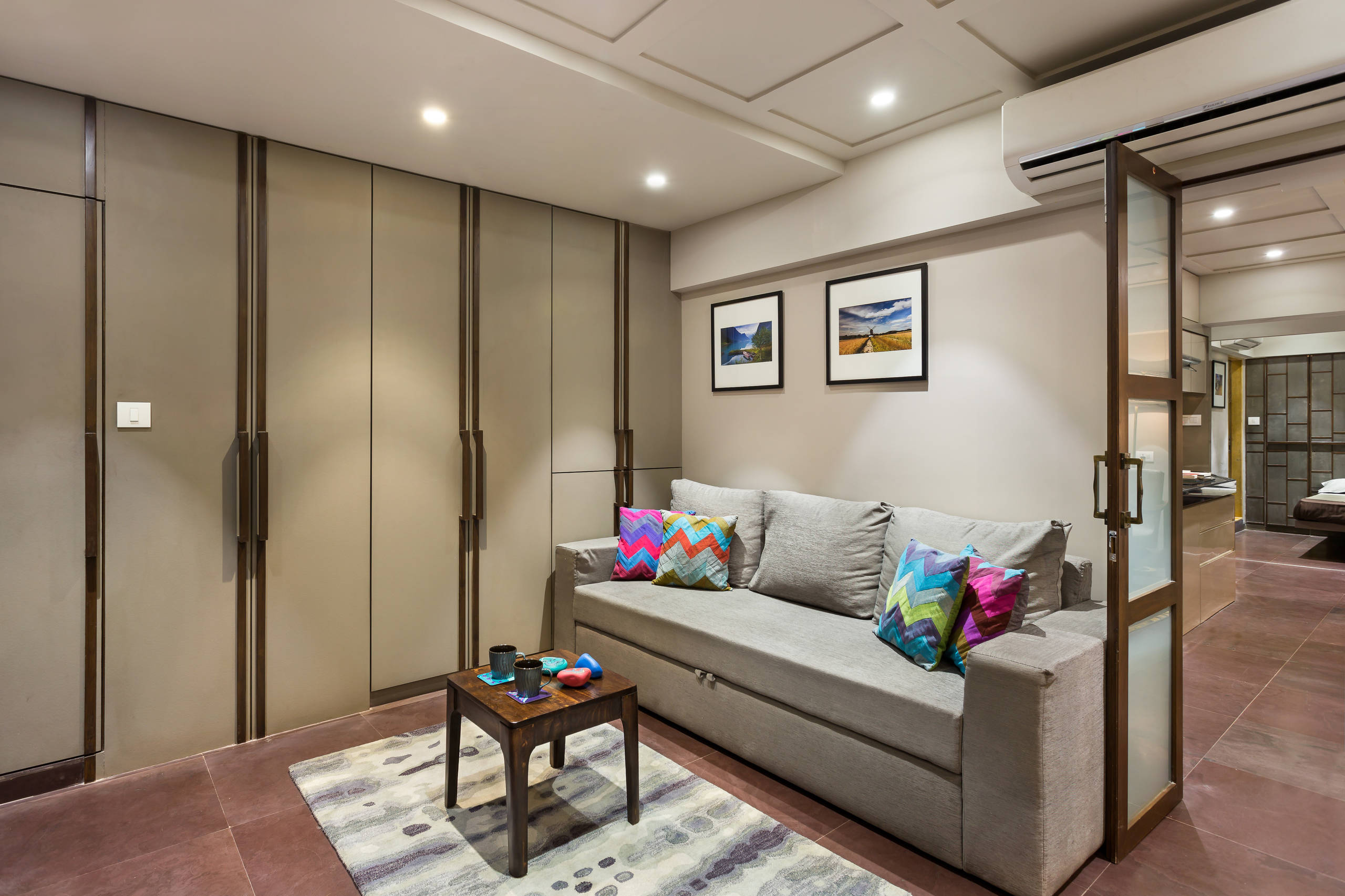 Small Indian apartment living room with full-height storage