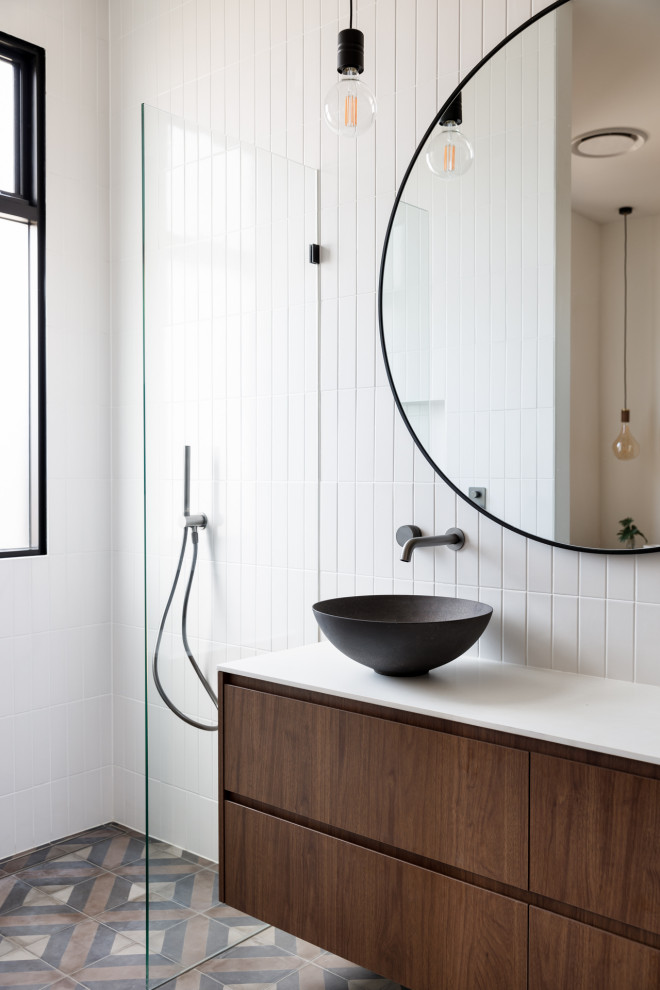Photo of a contemporary 3/4 bathroom in Sydney with medium wood cabinets, a curbless shower, a one-piece toilet, white tile, ceramic tile, white walls, cement tiles, a vessel sink, multi-coloured floor, a hinged shower door, white benchtops, a niche, a double vanity and a floating vanity.