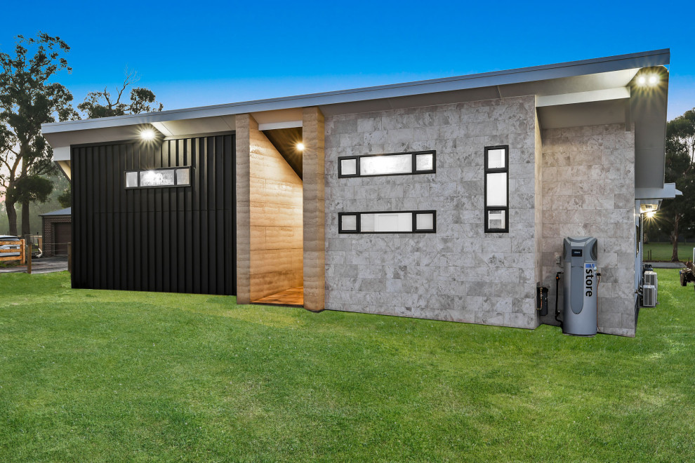 Inspiration for a large contemporary one-storey house exterior in Other with stone veneer, a flat roof and a metal roof.