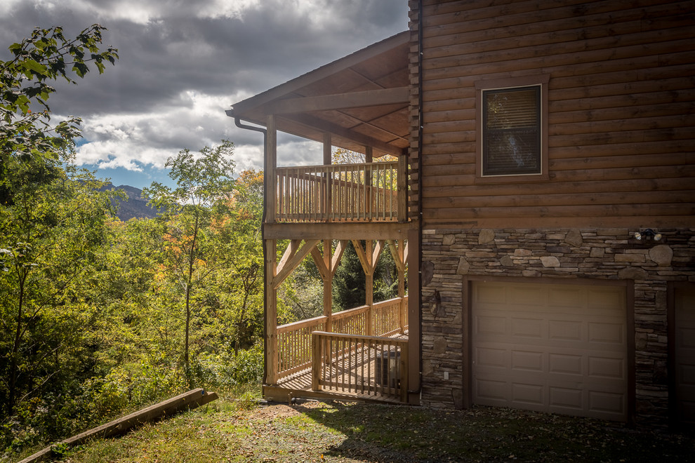 Deck - huge rustic backyard deck idea in Charlotte with a roof extension