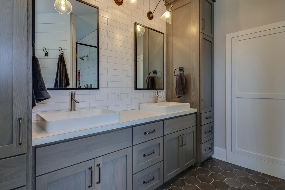Inspiration for a large contemporary master bathroom in Grand Rapids with shaker cabinets, distressed cabinets, a drop-in tub, a corner shower, a two-piece toilet, white tile, subway tile, grey walls, porcelain floors, a vessel sink, quartzite benchtops, black floor, a hinged shower door and white benchtops.