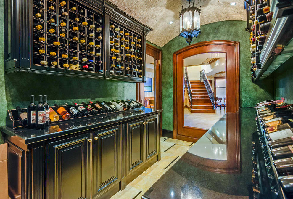 This is an example of a mediterranean wine cellar in Los Angeles with storage racks and multi-coloured floor.