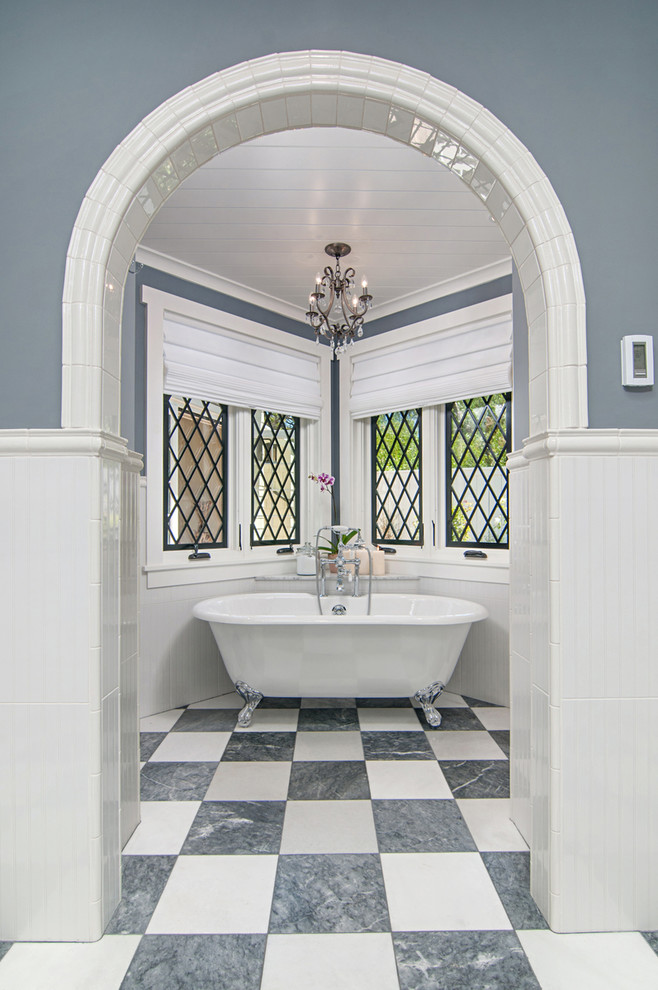 This is an example of a large traditional master bathroom in San Diego with beaded inset cabinets, white cabinets, a freestanding tub, a corner shower, white tile, porcelain tile, blue walls, porcelain floors, a drop-in sink and marble benchtops.