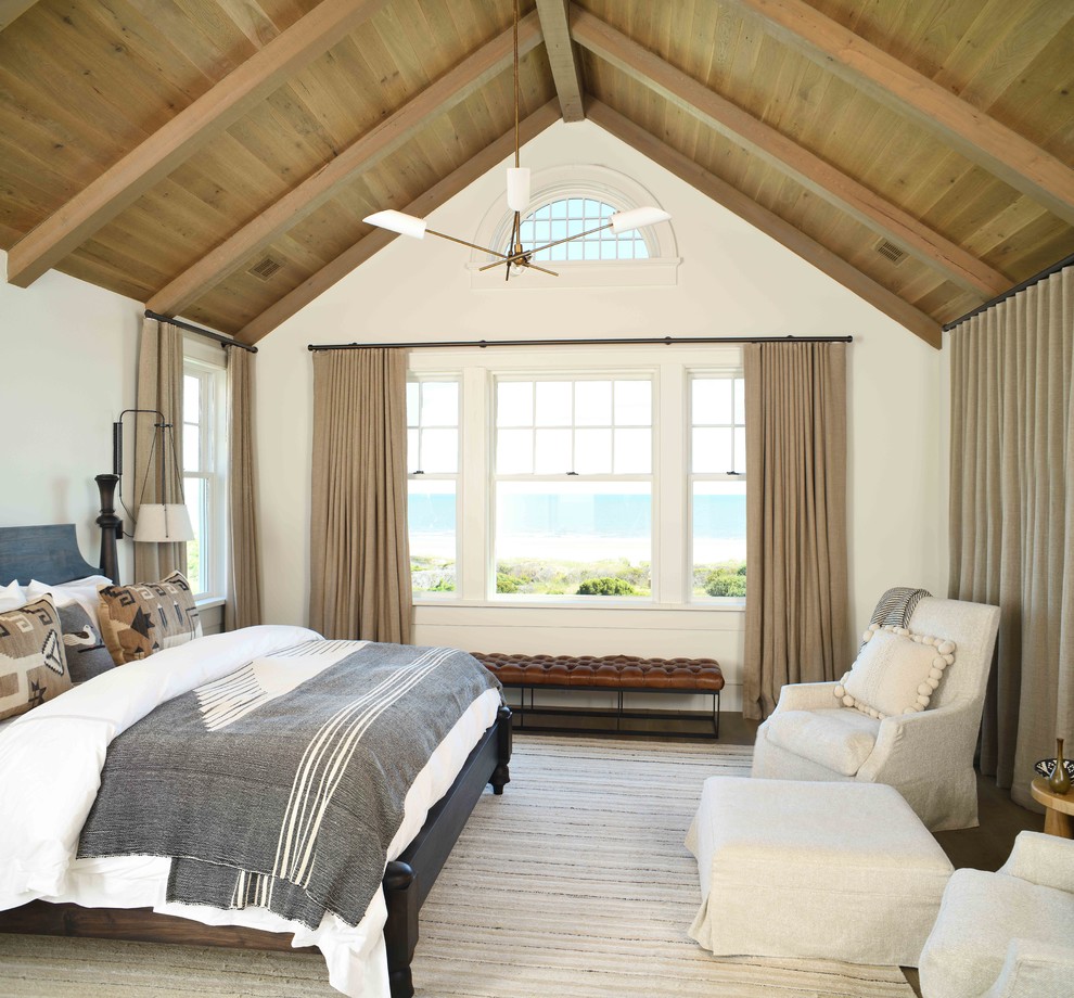 Design ideas for a beach style bedroom in Charleston with white walls, dark hardwood floors and brown floor.