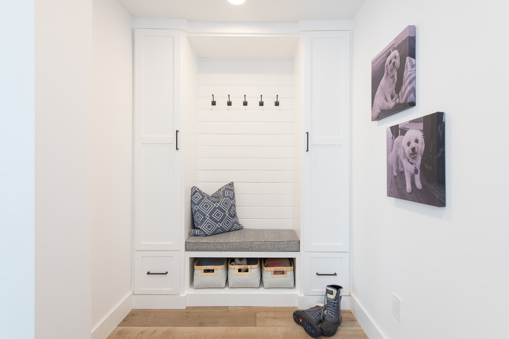 Design ideas for a mid-sized country hallway in Orange County with white walls, medium hardwood floors and brown floor.