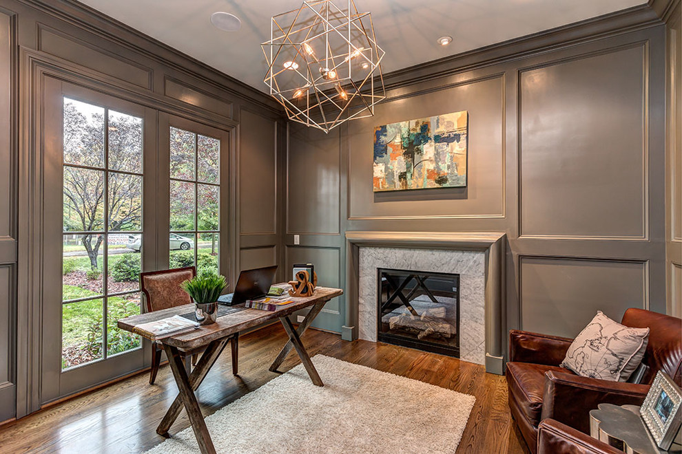 Traditional study room in Charlotte with grey walls, medium hardwood floors, a standard fireplace and a freestanding desk.