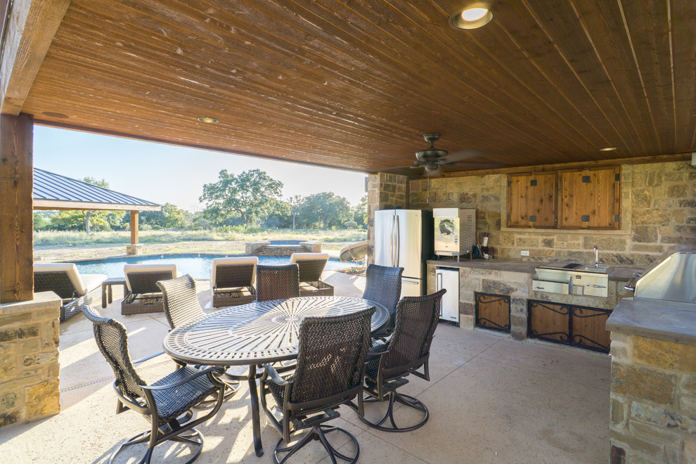 Inspiration for a large rustic backyard stone patio fountain remodel in Austin with a gazebo
