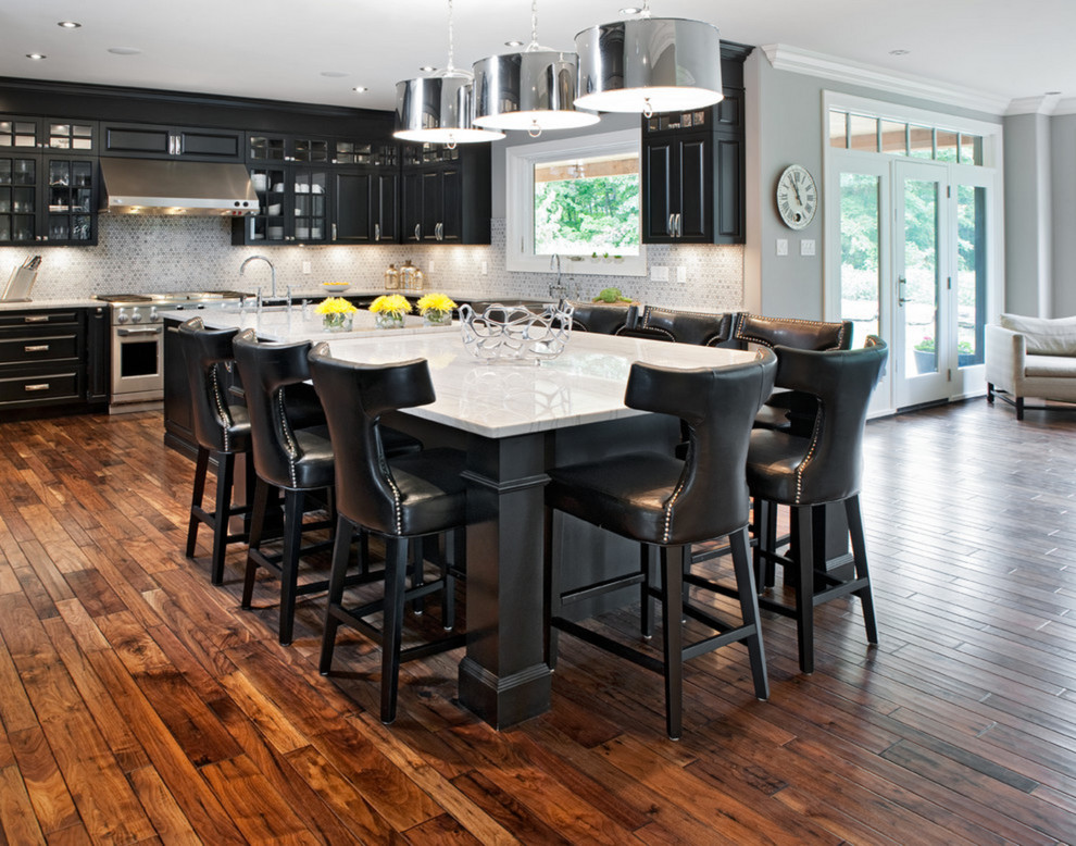 Inspiration for a large country l-shaped eat-in kitchen in Orange County with a farmhouse sink, raised-panel cabinets, black cabinets, quartz benchtops, grey splashback, ceramic splashback, stainless steel appliances, dark hardwood floors and with island.