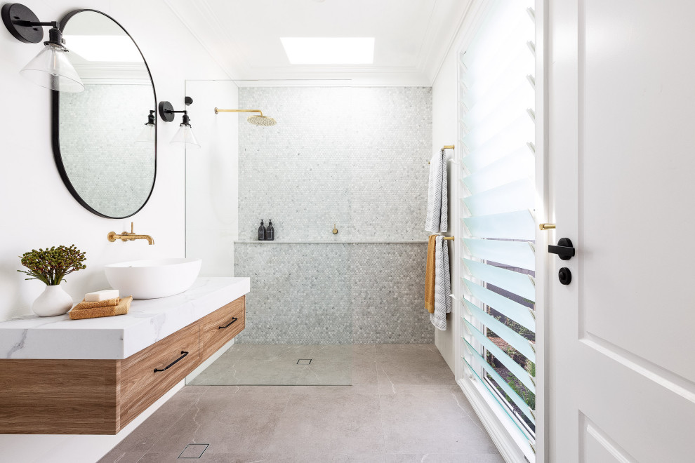 Mid-sized beach style 3/4 bathroom in Sydney with shaker cabinets, white walls, porcelain floors, a vessel sink, marble benchtops, grey floor, an open shower, white benchtops, a single vanity, a floating vanity, medium wood cabinets, a curbless shower, gray tile and mosaic tile.