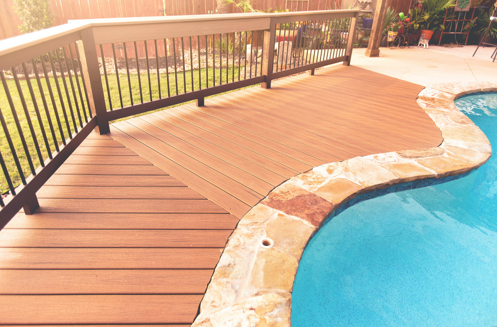 Example of a small backyard ground level mixed material railing deck design