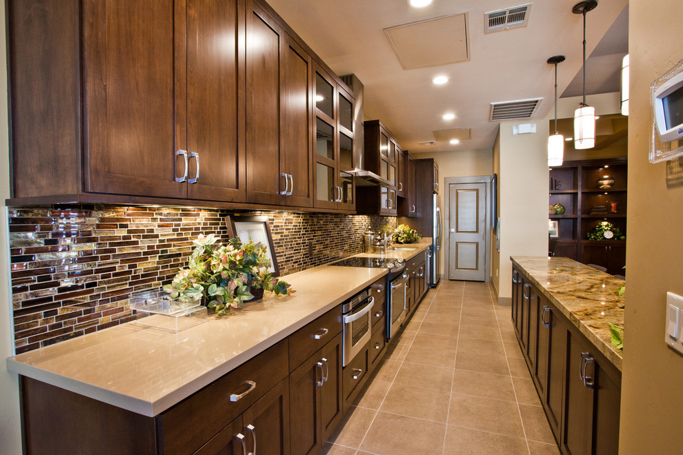 Inspiration for a large contemporary galley eat-in kitchen in Las Vegas with recessed-panel cabinets, dark wood cabinets, marble benchtops, brown splashback, mosaic tile splashback, stainless steel appliances and with island.