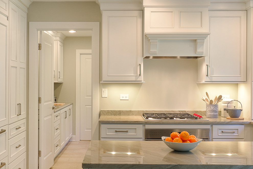 Example of a small transitional galley light wood floor eat-in kitchen design in Chicago with an undermount sink, recessed-panel cabinets, white cabinets, quartzite countertops, gray backsplash, stone slab backsplash, stainless steel appliances and a peninsula