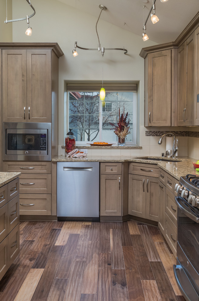 Inspiration for a mid-sized transitional galley medium tone wood floor eat-in kitchen remodel with an undermount sink, recessed-panel cabinets, gray cabinets, quartz countertops, beige backsplash, ceramic backsplash, stainless steel appliances and no island