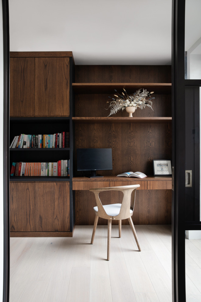 Idée de décoration pour un petit bureau design de type studio avec un mur gris, un sol en bois brun, aucune cheminée, un bureau intégré et un sol beige.