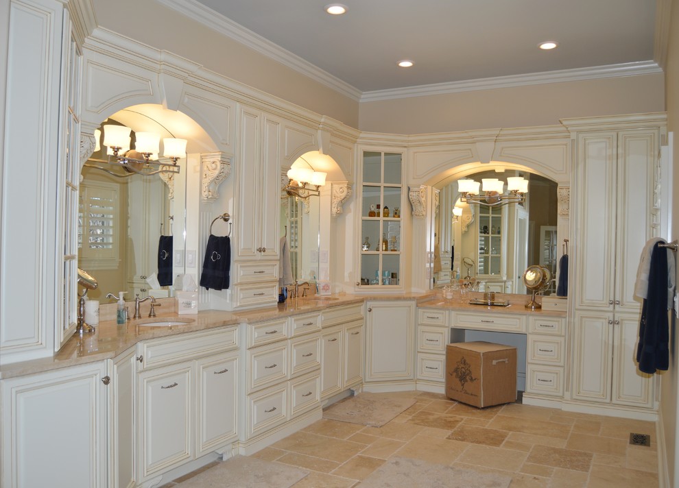 Large transitional master bathroom in Atlanta with an undermount sink, raised-panel cabinets, white cabinets, limestone benchtops, a drop-in tub, a double shower, a one-piece toilet, beige tile, stone tile, beige walls and limestone floors.