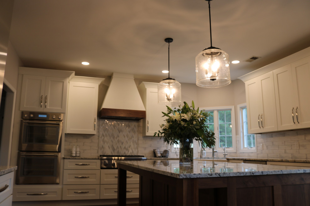 Exempel på ett stort klassiskt vit vitt kök och matrum, med en rustik diskho, skåp i shakerstil, granitbänkskiva, vitt stänkskydd, stänkskydd i tunnelbanekakel, rostfria vitvaror, mellanmörkt trägolv och en köksö