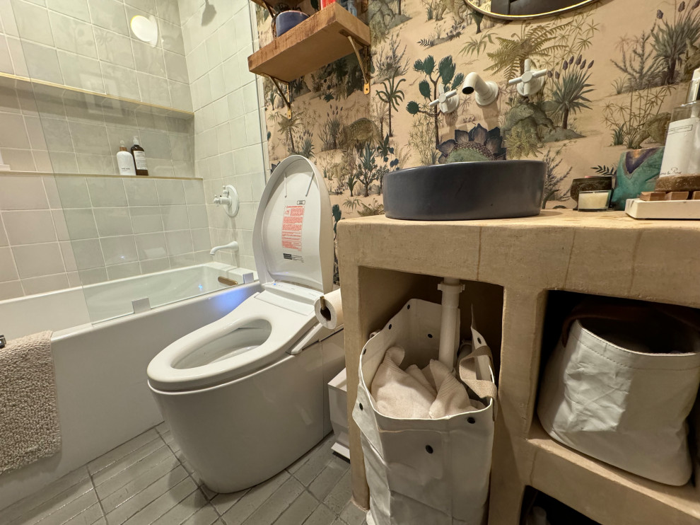 Photo of a mid-sized tropical 3/4 bathroom in Los Angeles with beige cabinets, a japanese tub, porcelain tile, ceramic floors, solid surface benchtops, a niche and wallpaper.