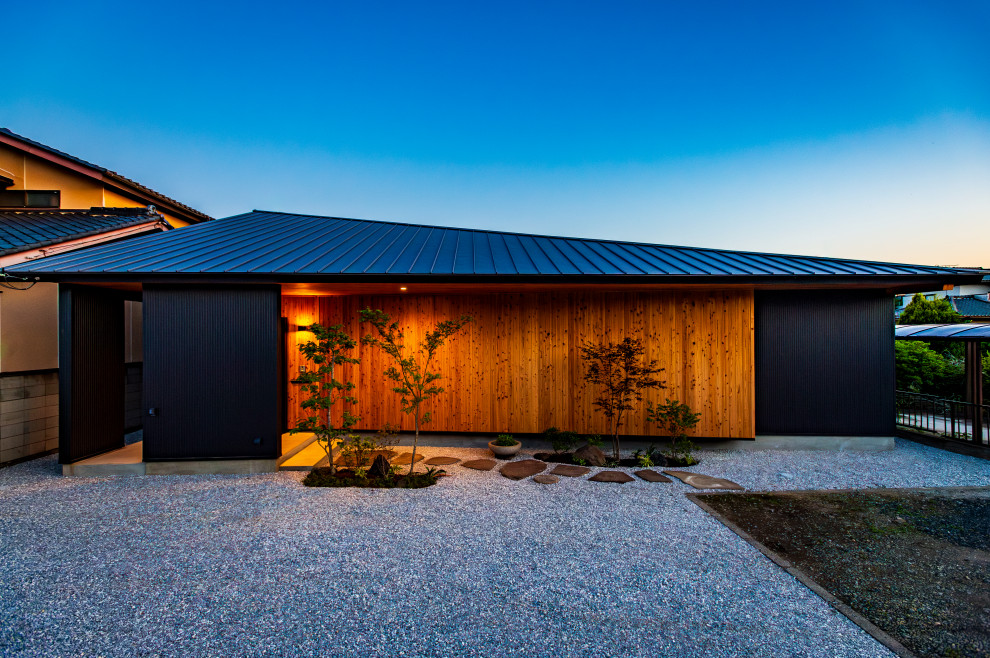 Diseño de fachada de casa negra y gris de tamaño medio de una planta con revestimientos combinados, tejado de un solo tendido, tejado de metal y panel y listón
